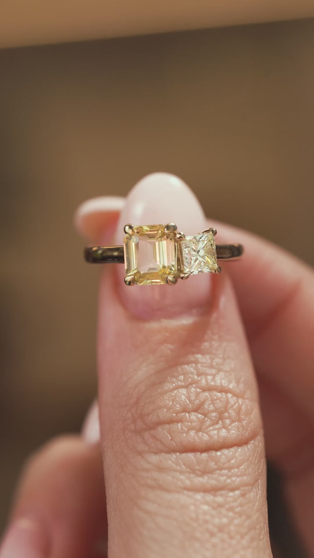 A video of a Antique-inspired, Diamond and yellow sapphire Toi et Moi engagement ring held in the fingers and turned to show angles
