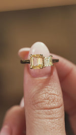 A video of a Antique-inspired, Diamond and yellow sapphire Toi et Moi engagement ring held in the fingers and turned to show angles