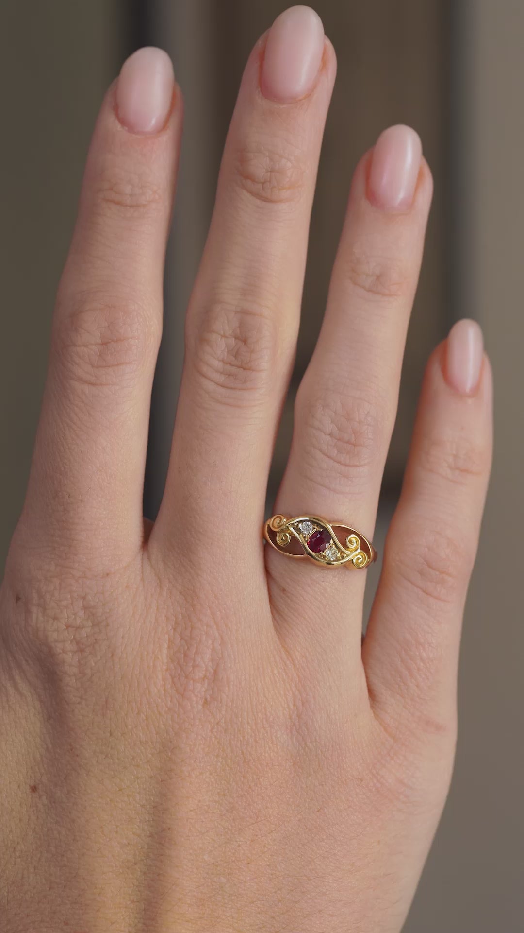 Video showcasing the antique ruby and diamond ring on the hand from a wider perspective.