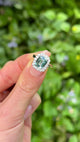 Vintage, 1960s Teal Sapphire and Diamond Square Cluster Ring, 18ct White Gold held in fingers.