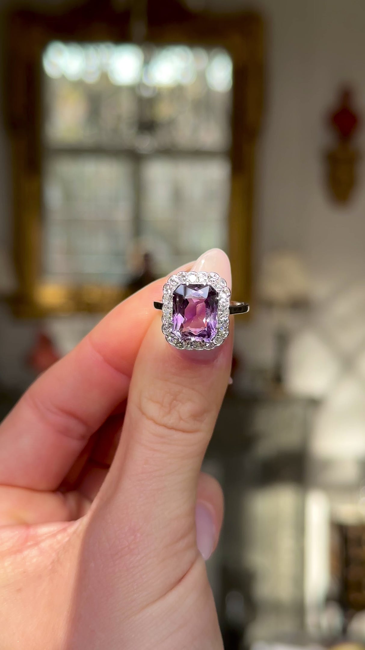 antique belle epoque amethyst and diamond cluster ring held in fingers and moved around to give perspective.