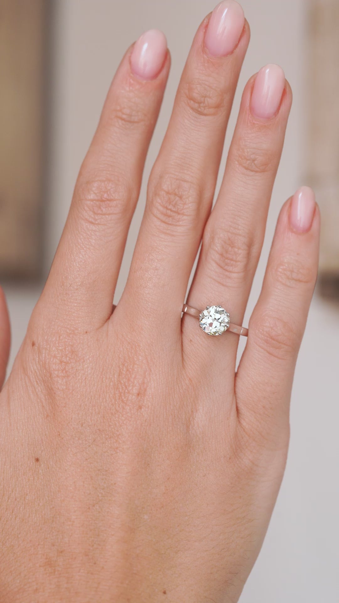 Video of the antique platinum solitaire ring on the hand, capturing the character of its warm old-cut diamond.