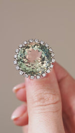 A close-up video showcasing the green quartz cluster ring held between fingertips, revealing its shifting green hues and diamond detailing.