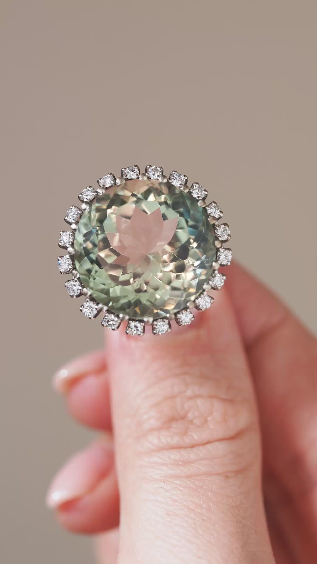 A close-up video showcasing the green quartz cluster ring held between fingertips, revealing its shifting green hues and diamond detailing.