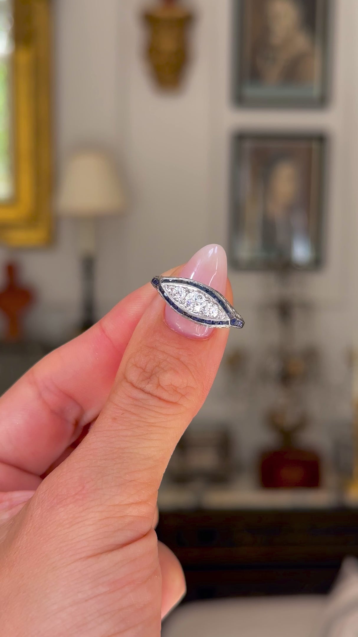 Antique Edwardian sapphire and diamond ring held in fingers and moved around to give perspective.