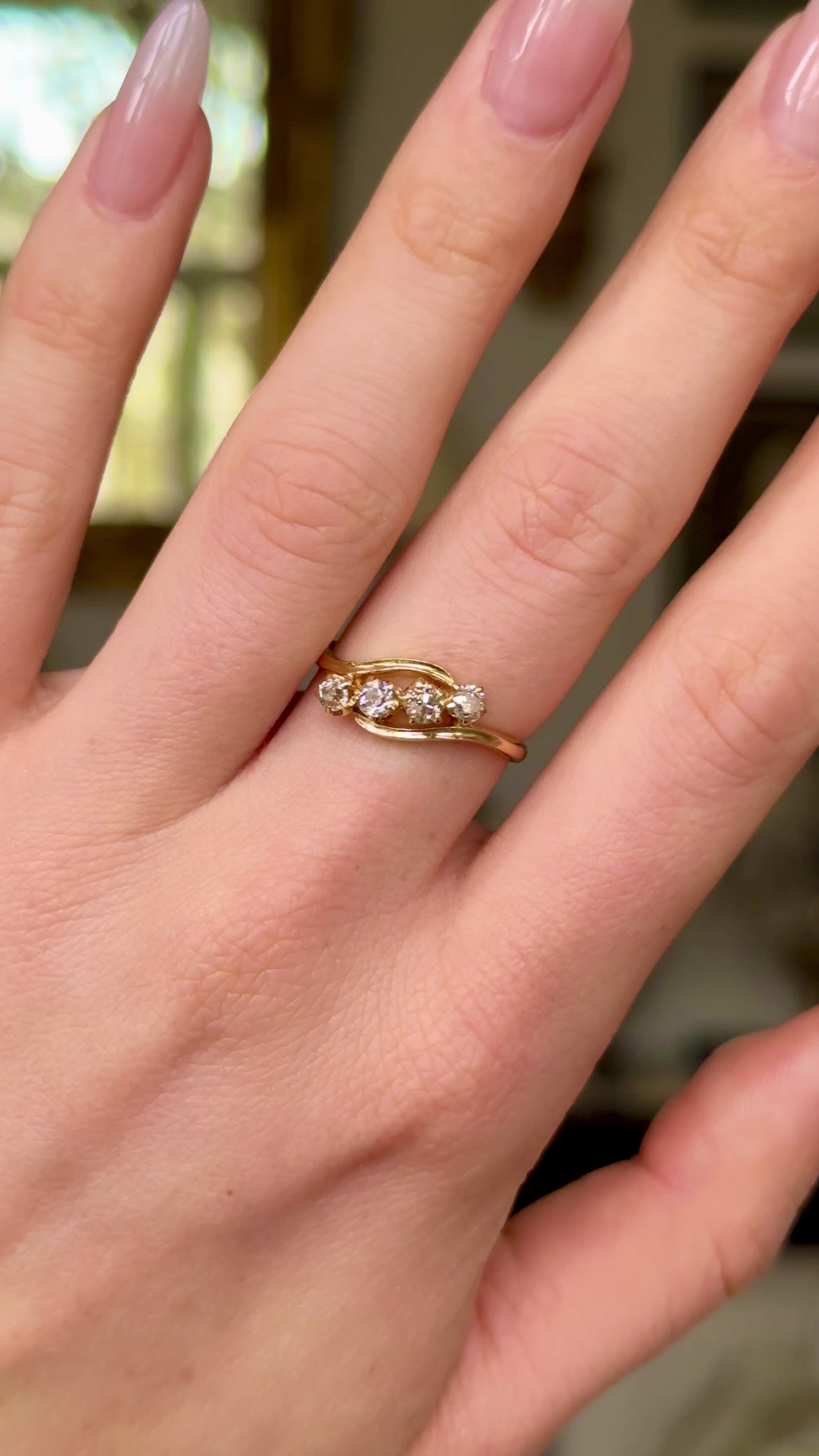 Antique four-stone diamond ring worn on hand and moved around to give perspective.