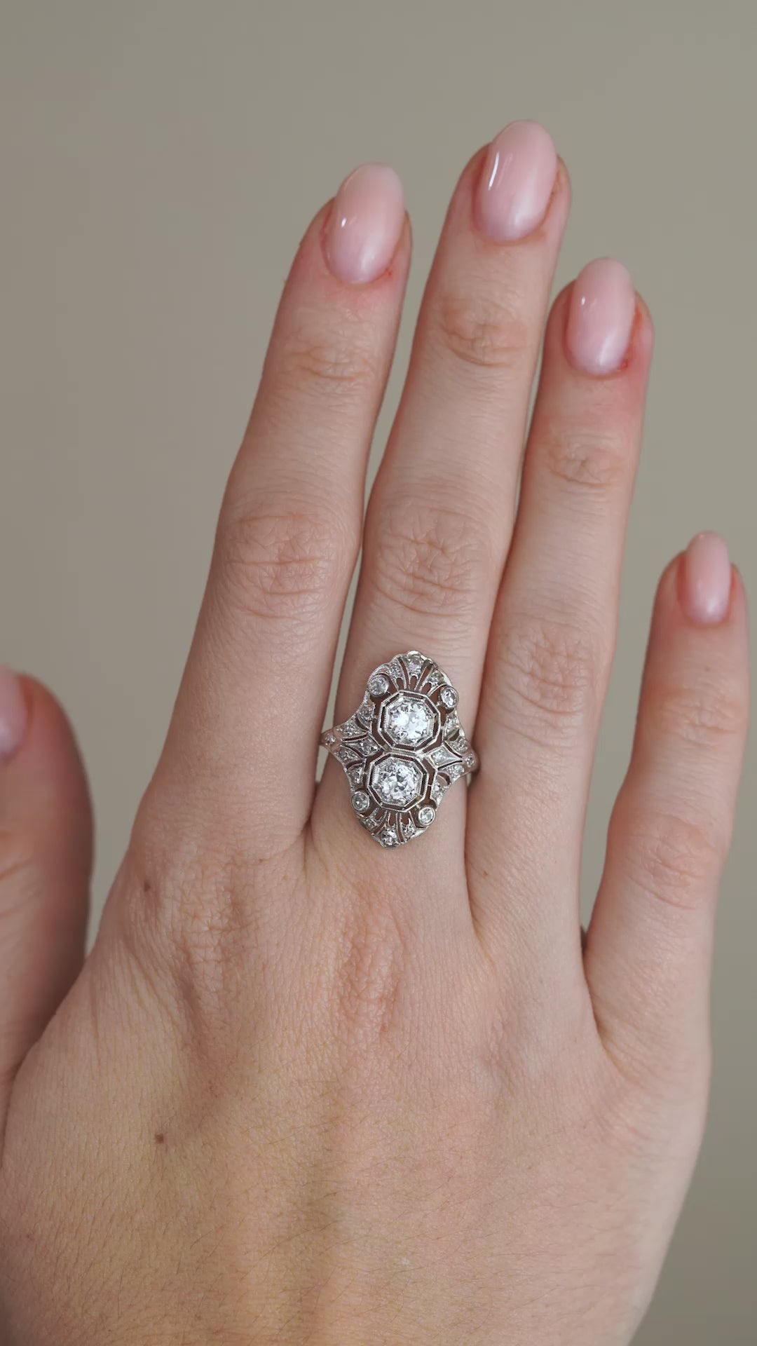 A video of the Art Deco filigree ring worn on a finger, highlighting the symmetrical diamond arrangement and decorative openwork design.