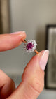 Video of a yellow gold Vintage, 1940s ruby and diamond cluster engagement ring held between two fingers and rotated slowly to view all angles