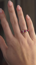 Video showcasing the antique ruby and diamond five-stone ring on the hand from a wider perspective.