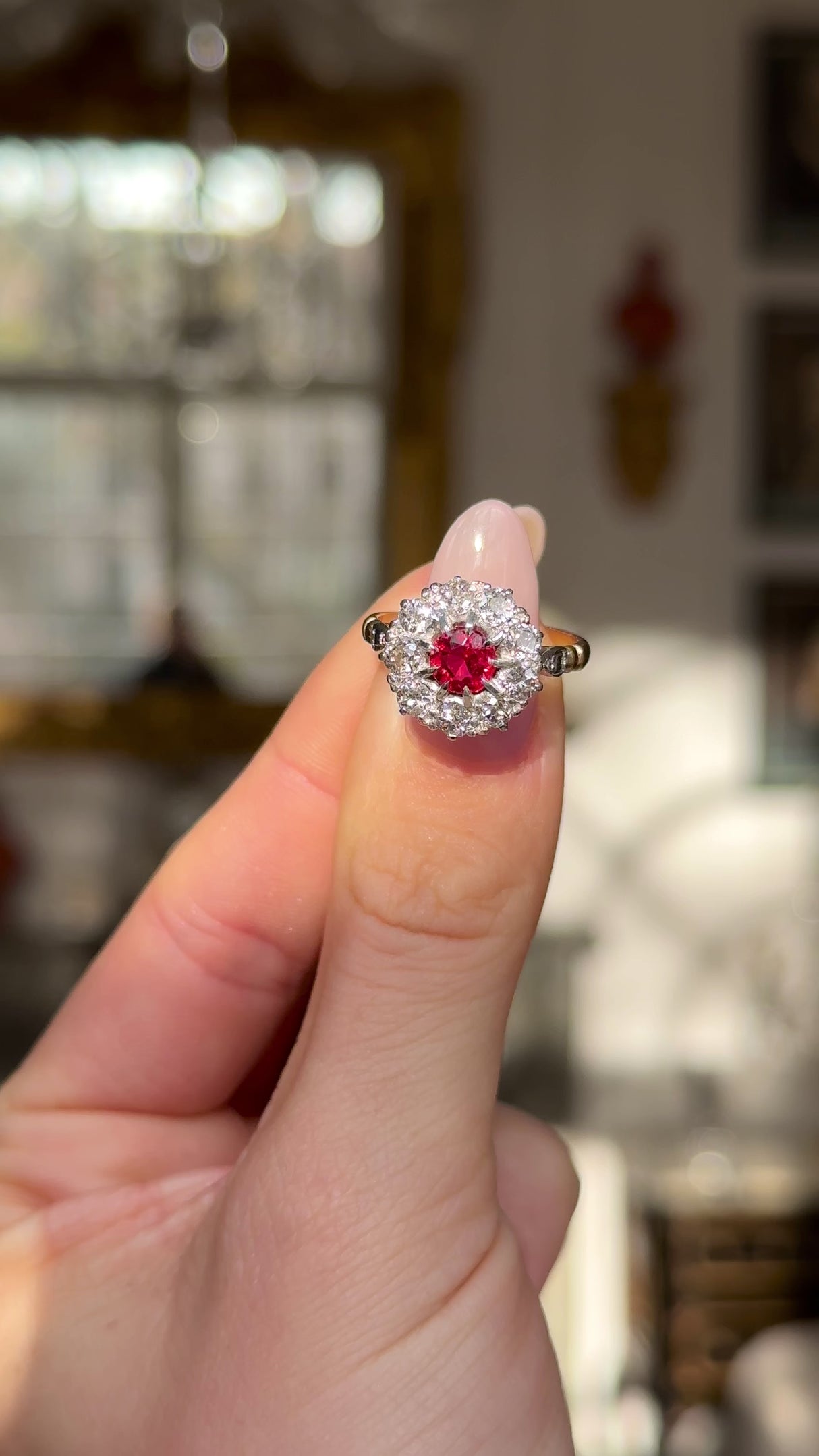 Antique victorian ruby and diamond cluster engagement ring held inf igners and moved around to give perspective.