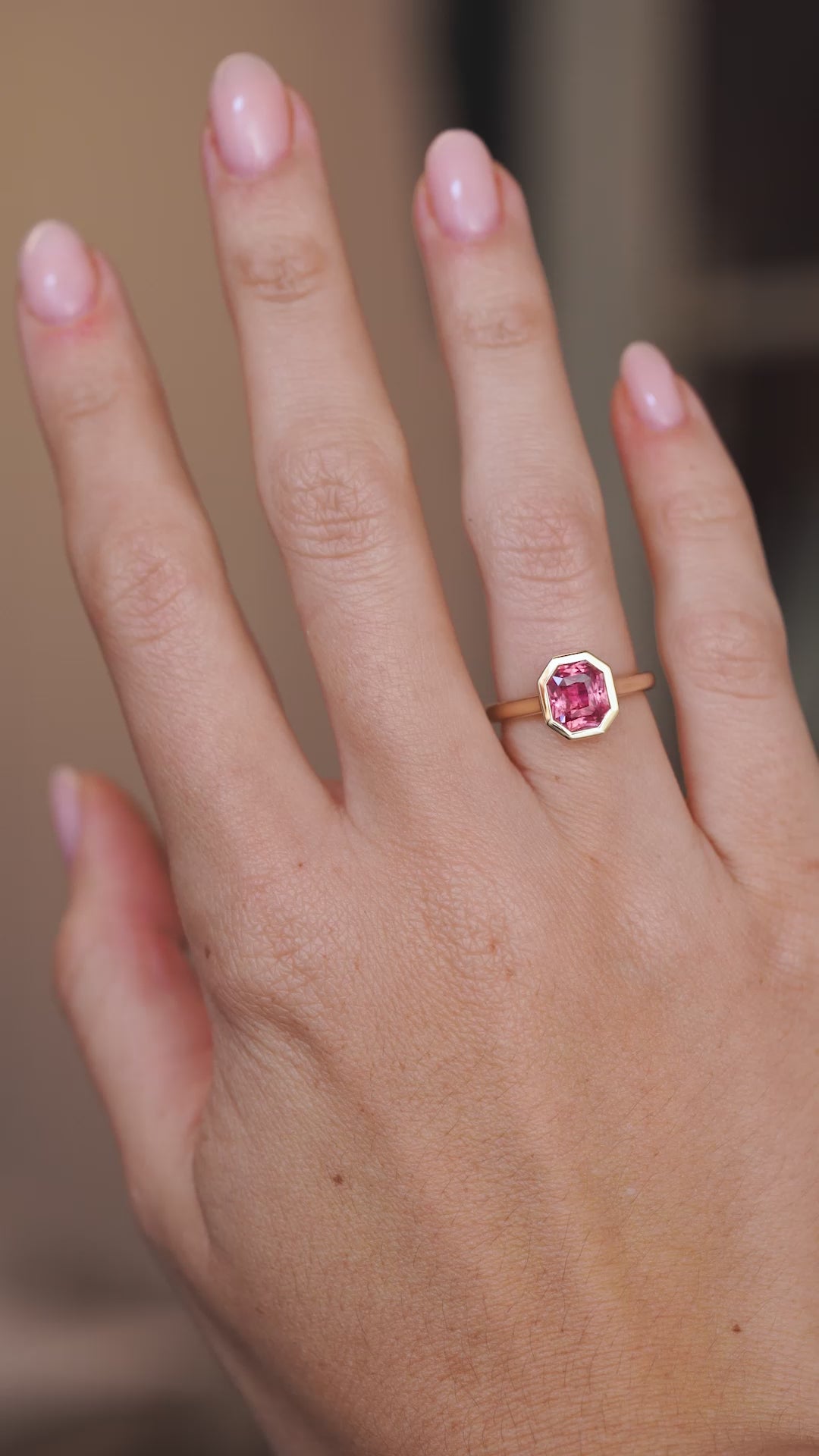 Video of the antique-inspired sapphire solitaire on the hand, capturing the gemstone’s shifting peach and pink tones.