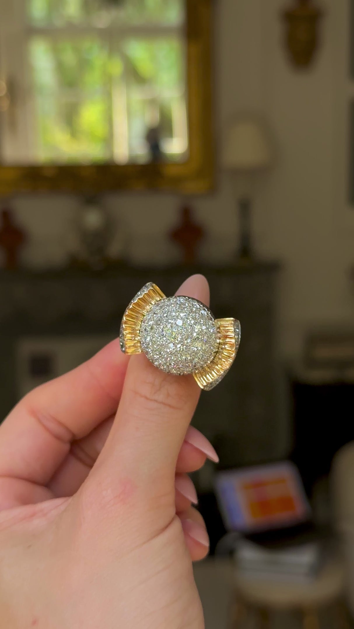 Cartier diamond bombe ring held in fingers and moved around to give perspective.
