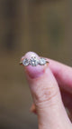 Close detail video of antique Art Deco diamond three-stone ring with raised diamond setting and yellow gold band.