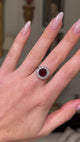 Edwardian garnet and diamond cluster ring, worn on hand and moved away from camera to give perspective.