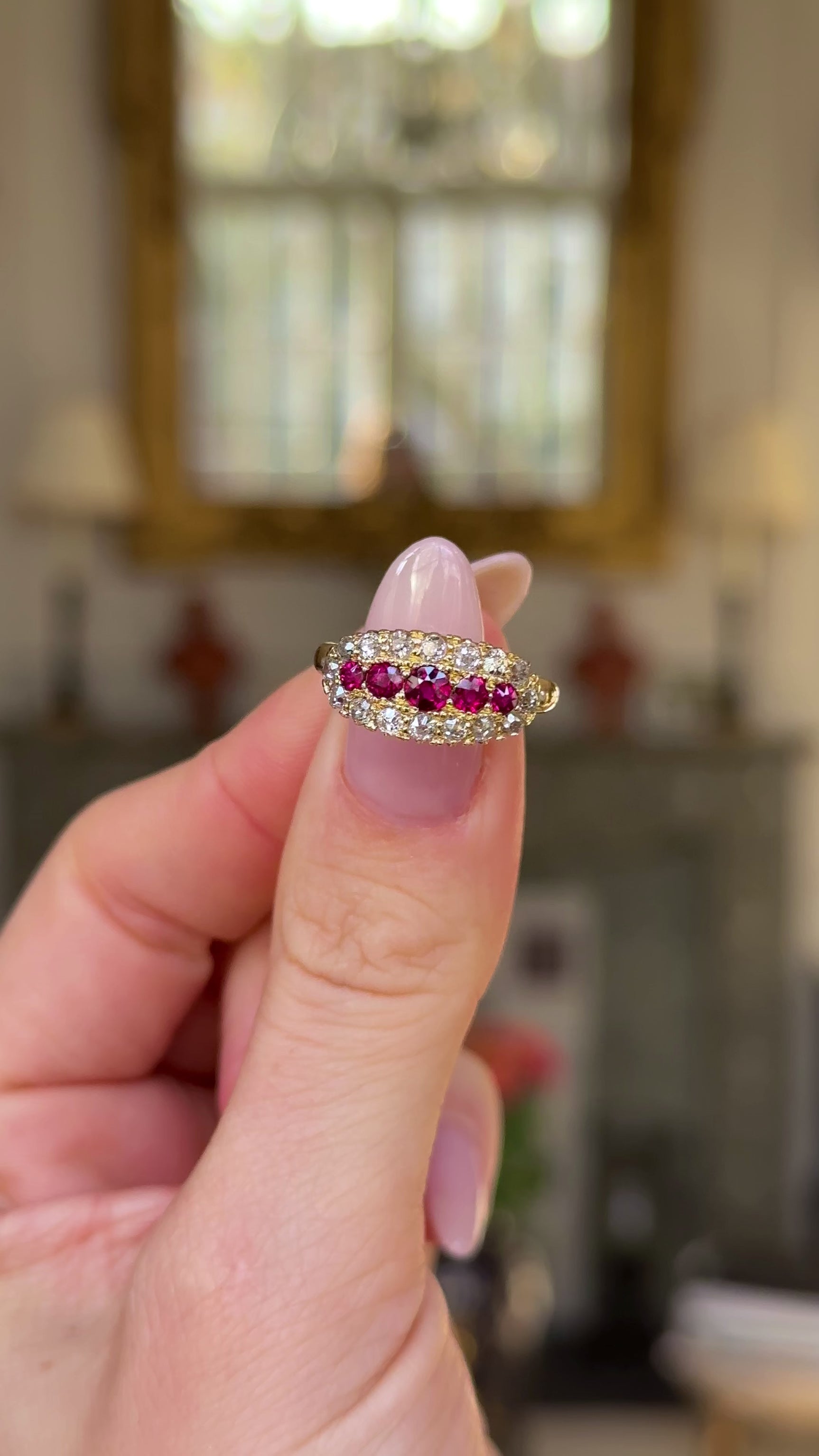 Ruby and diamond cluster engagement ring held in figners and moved around to give perspective.