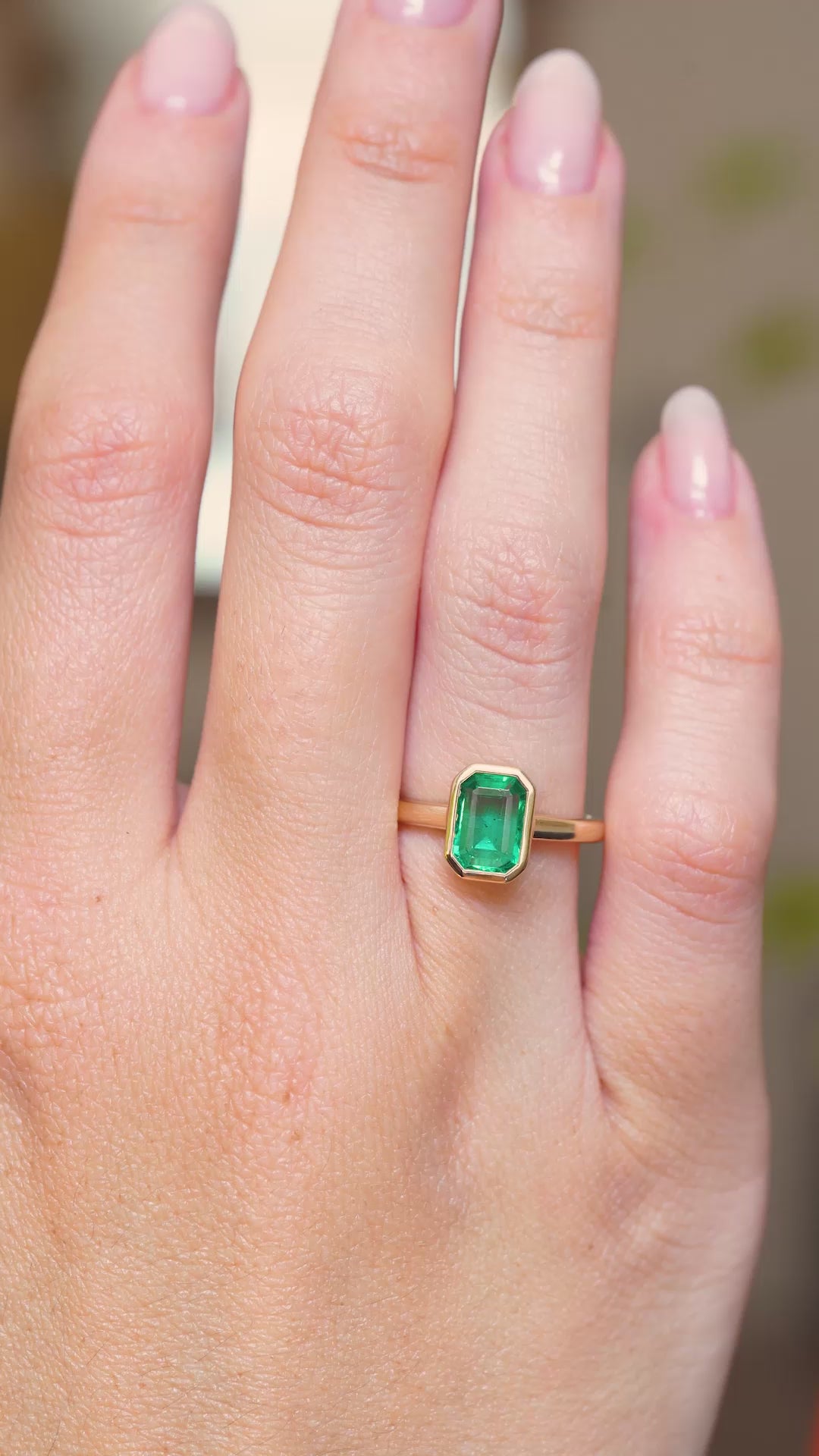 A video of an emerald engagement ring in yellow gold showcased on the hand with an antique-inspired setting.