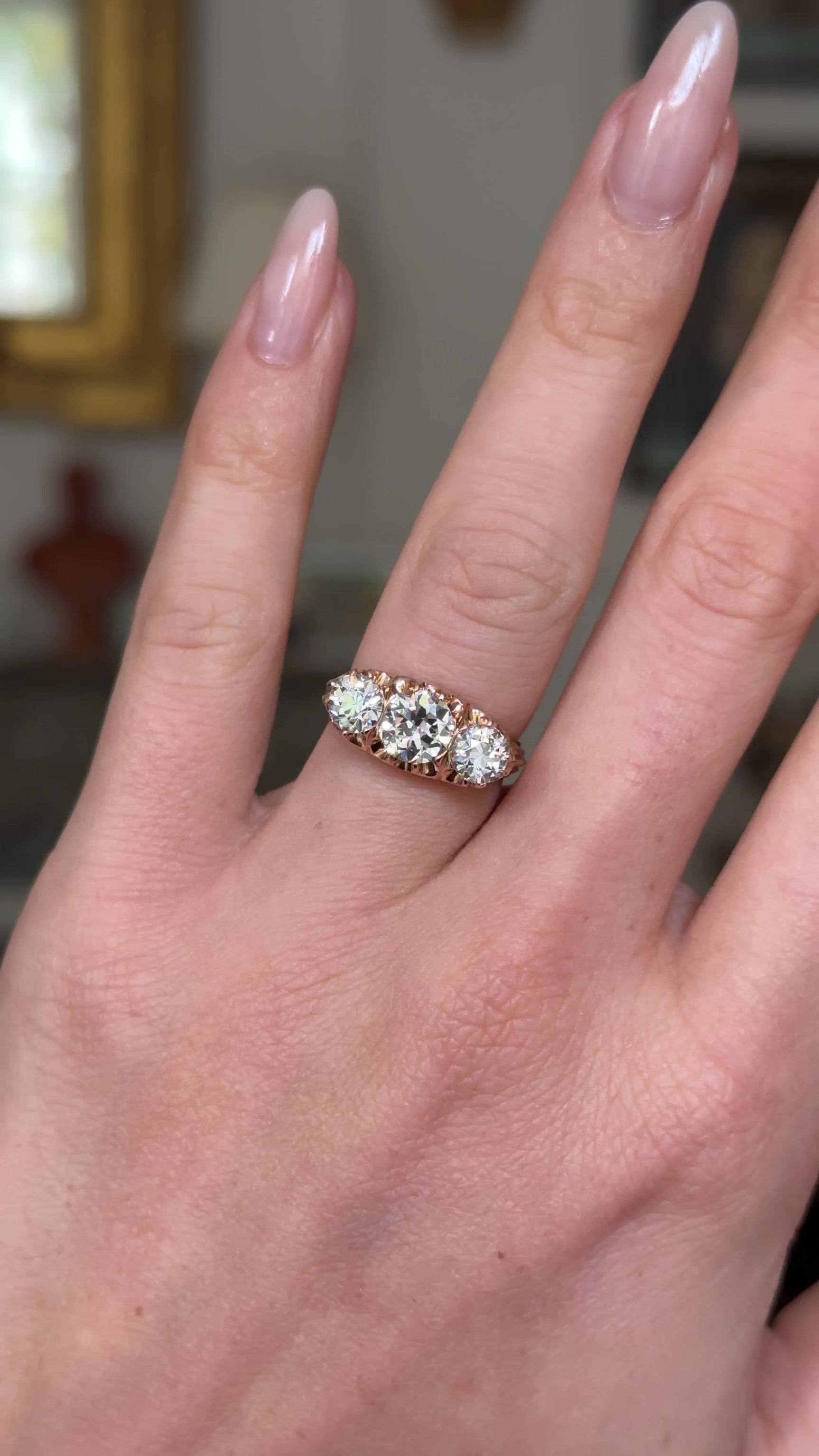 three stone antique italian diamond engagement ring, worn on hand and moved away from lens to give perspective,  front view. 