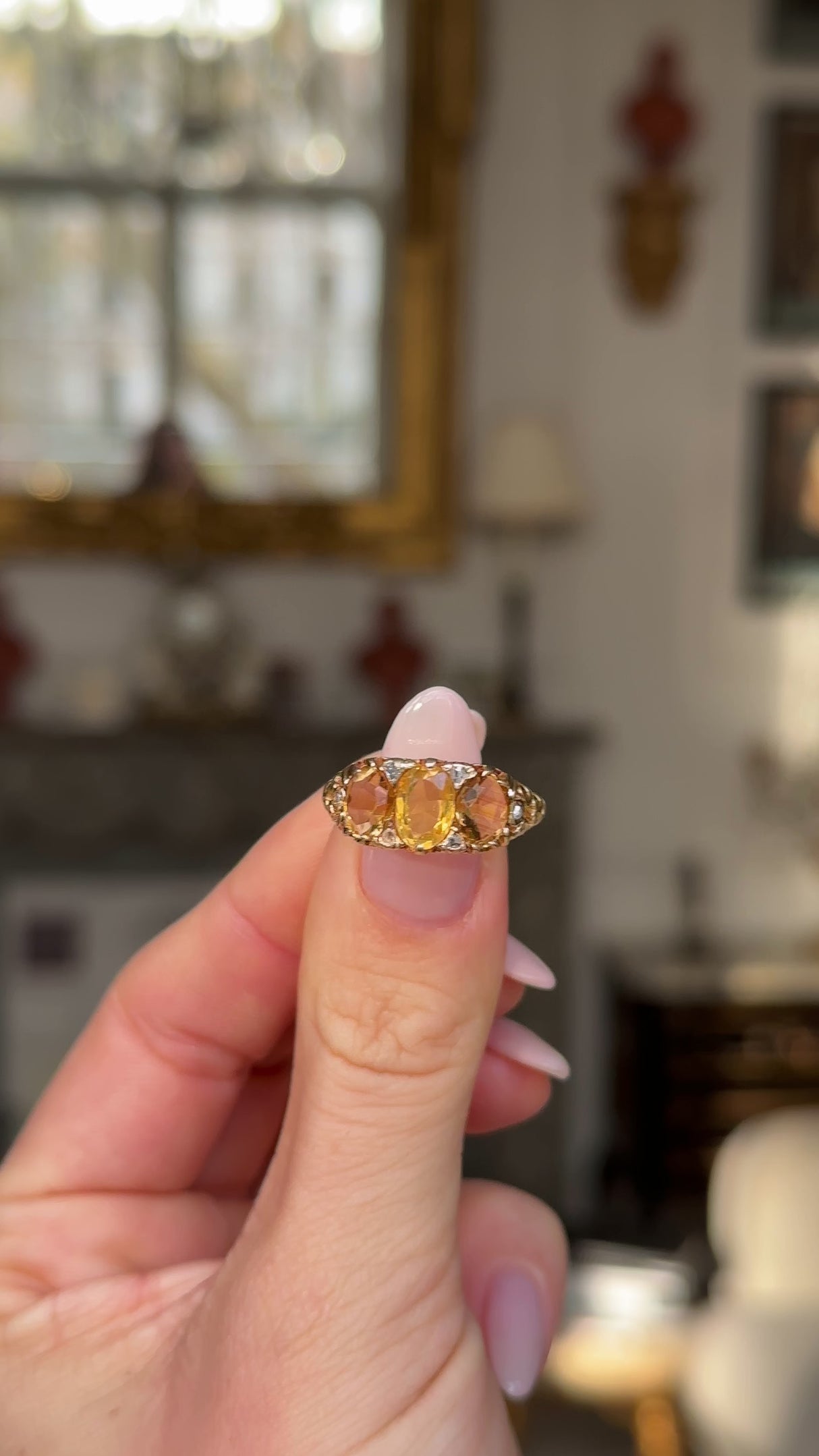 Three stone citrine ring held in fingers and moved around to give perspective.