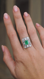 Video of the antique Colombian emerald ring on the hand, capturing the vivid green stone and surrounding diamond sparkle.