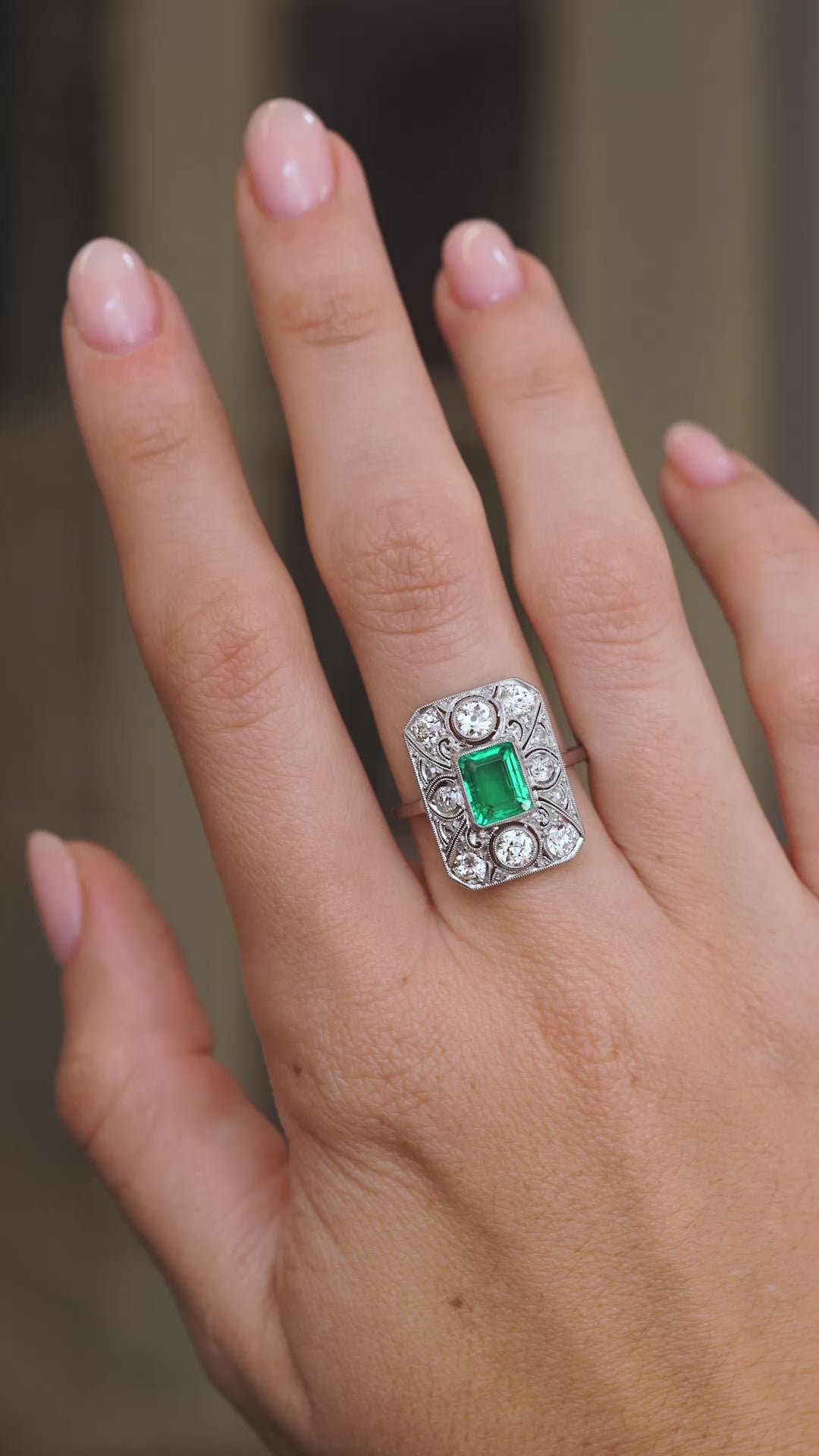 Video of the antique Colombian emerald ring on the hand, capturing the vivid green stone and surrounding diamond sparkle.
