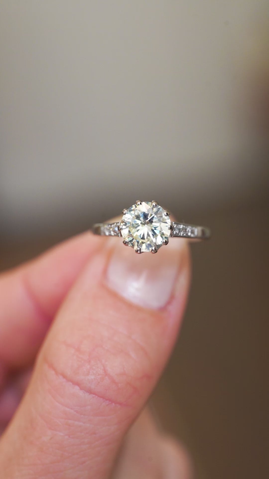 Vintage tinted yellow diamond ring showing light reflections and diamond set shoulders.