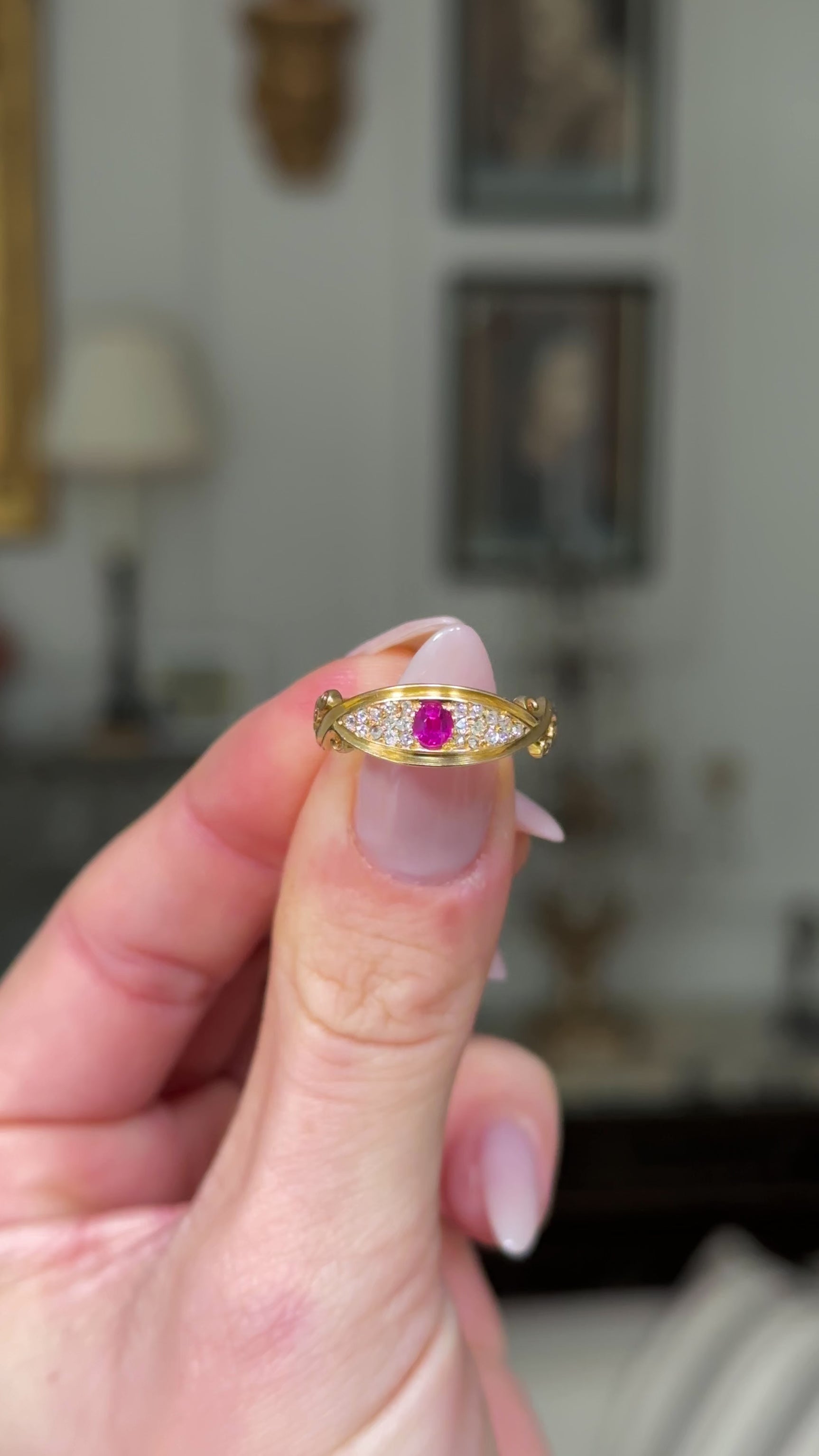 edwardian ruby and diamond 18ct yellow gold band held in fingers and rotated to give perspective. 