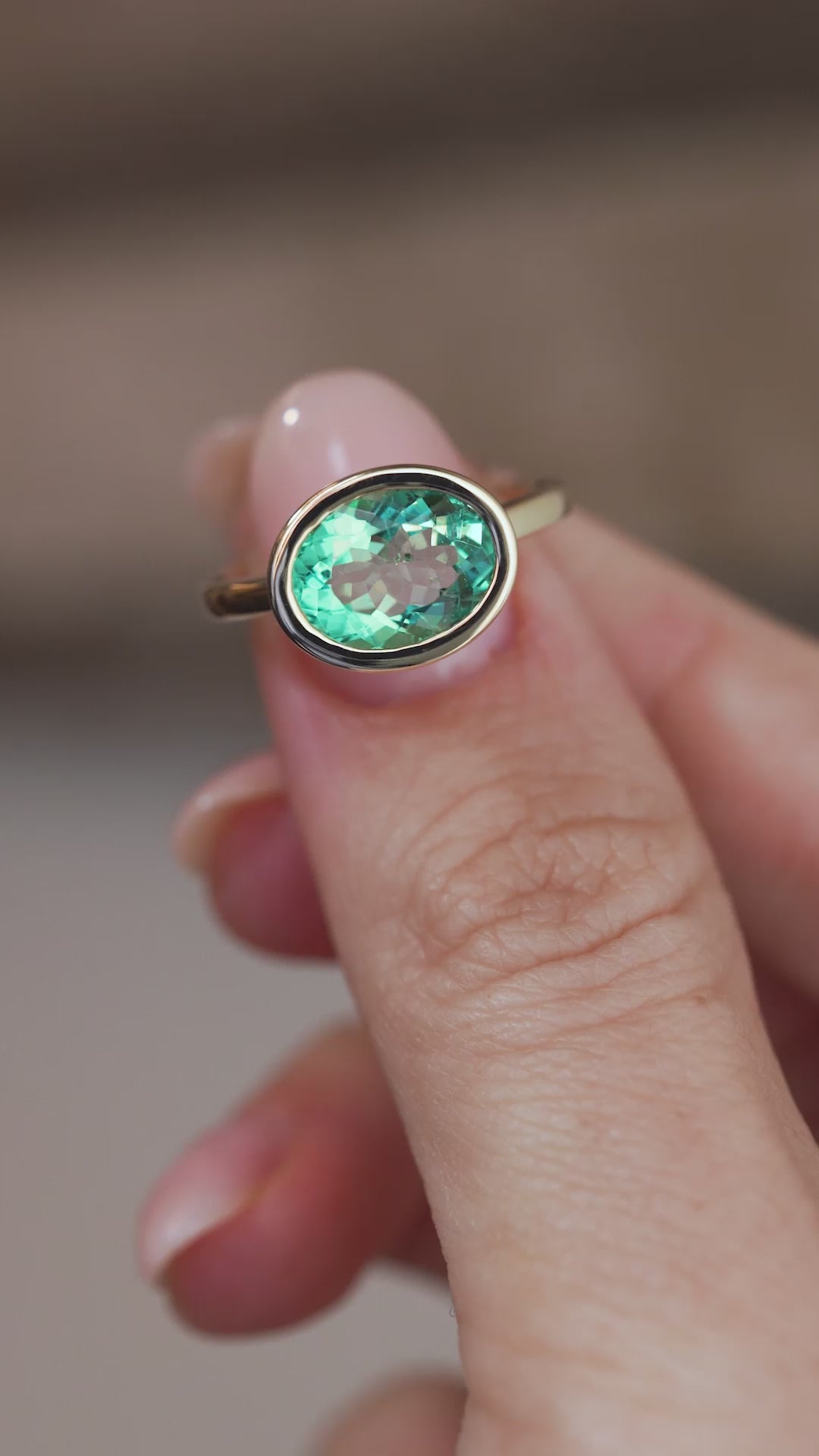 A close-up video of the beryl solitaire ring held between fingers, showcasing the gemstone's natural colour variations and faceted surface.