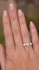 A video of an outstretched hand wearing an Antique, Edwardian brown diamond three-stone engagement ring in yellow gold with platinum settings, shown for scale.