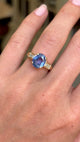 Vintage 1990s sapphire and diamond engagement ring featuring an oval blue sapphire centre stone with diamond-set shoulders, displayed on a hand.