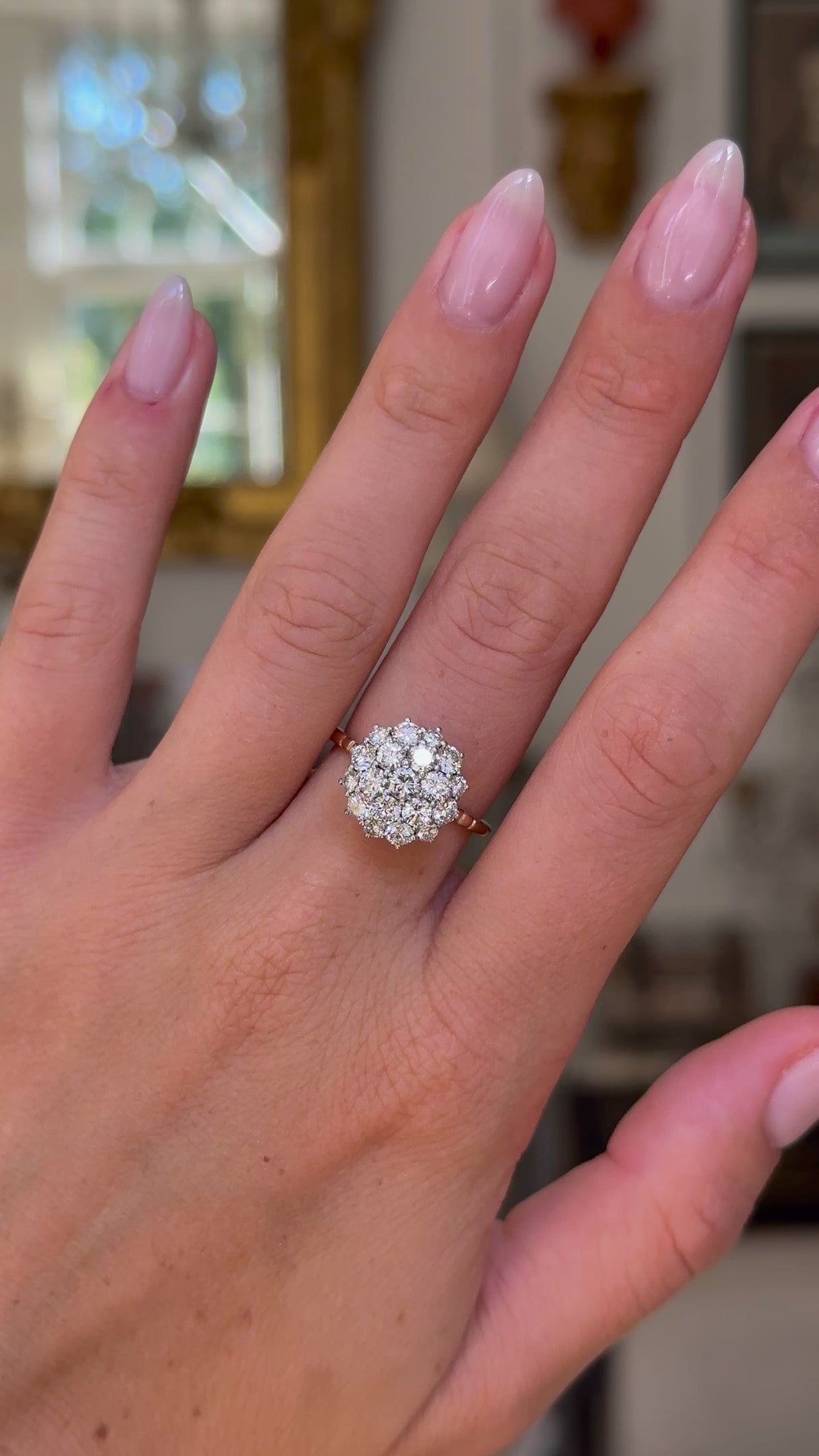 1980s diamond cluster engagement ring worn on hand and moved around to give perspective.
