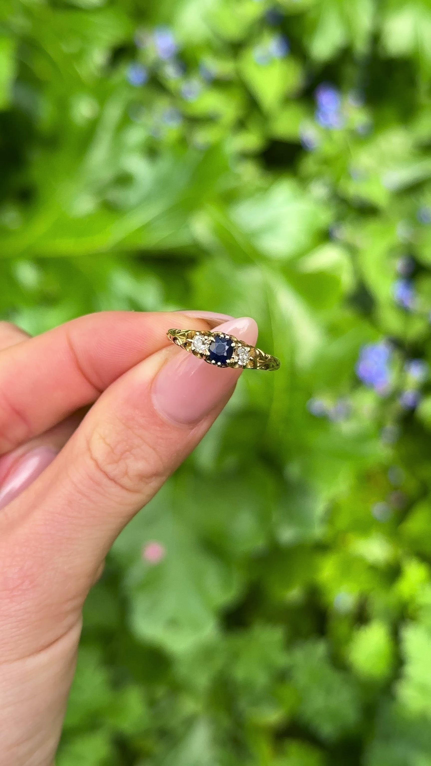 Antique, Edwardian Sapphire and Diamond Three-Stone Ring, 18ct Yellow Gold held in fingers.