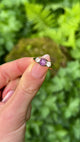 Antique, Edwardian Cabochon Star Ruby and White Sapphire Three-Stone Ring, 15ct Gold held in fingers.