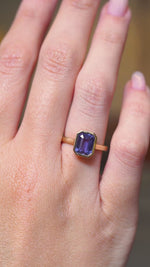 A video of an antique-inspired indigo blue sapphire solitaire engagement ring in yellow gold worn on a hand.