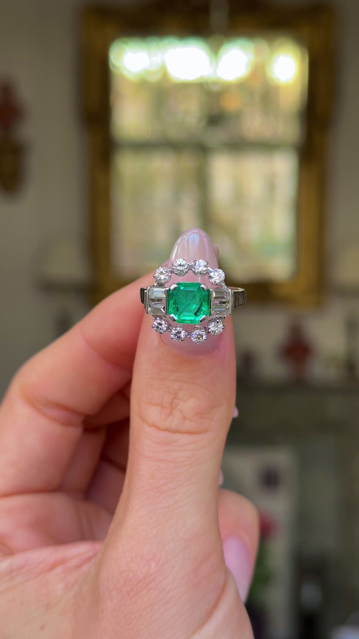 Vintage emerald and diamond ring held in fingers and moved around to give perspective,