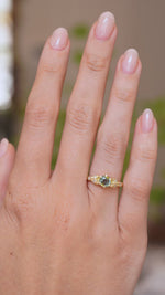  A video of a hand wearing a Vintage-inspired, Green sapphire and diamond engagement ring in yellow gold on a wedding finger. 