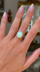cabochon white opal cocktail ring with 18ct yellow gold band, worn on hand and moved away from lens to give perspective, front view. 