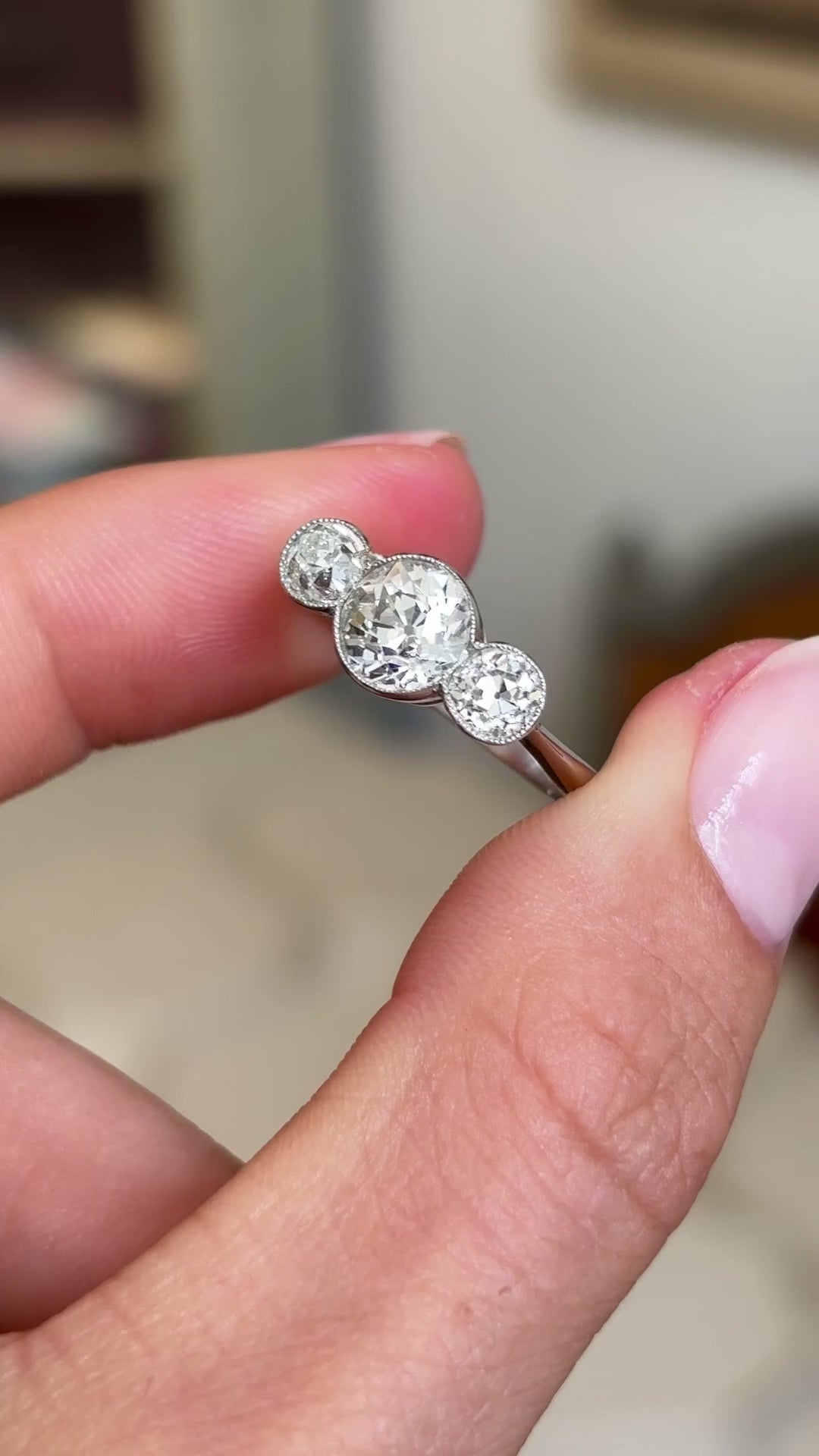 Video of an Antique, Art Deco platinum three-stone diamond engagement ring rotated to showcase the old-cut diamonds