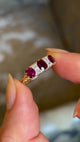 Antique, Victorian ruby and diamond three-stone ring held in fingers and rotated slowly to show fine details 