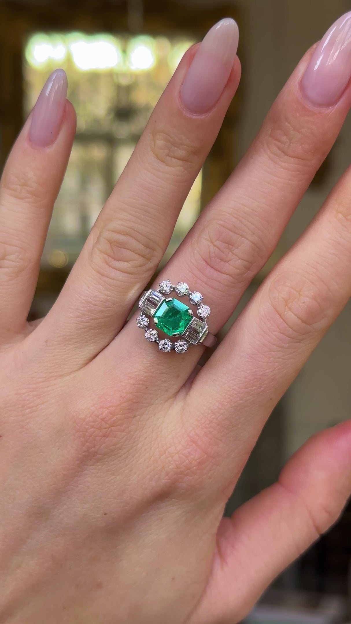 Vintage emerald and diamond ring worn on hand and moved around to give perspective.