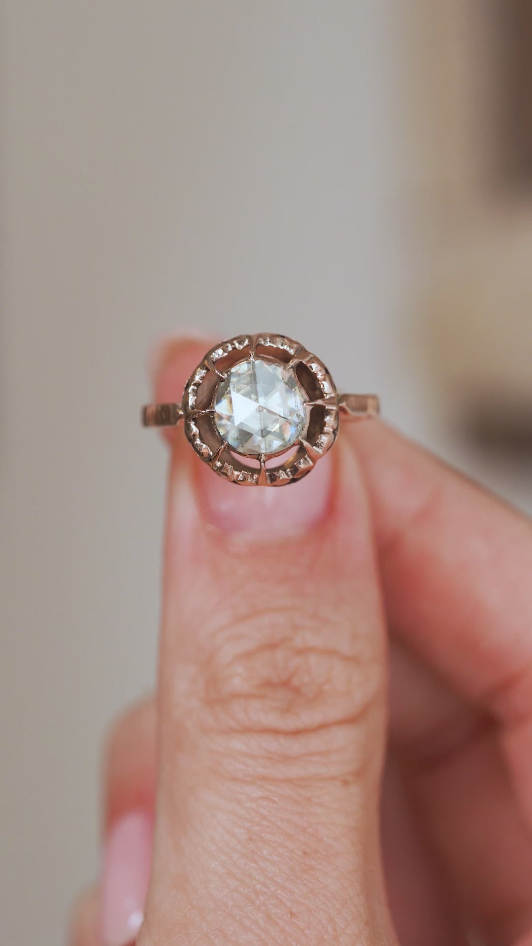 Video close-up of a Victorian rose-cut diamond ring balanced on a fingertip, capturing its distinctive sparkle and antique construction.