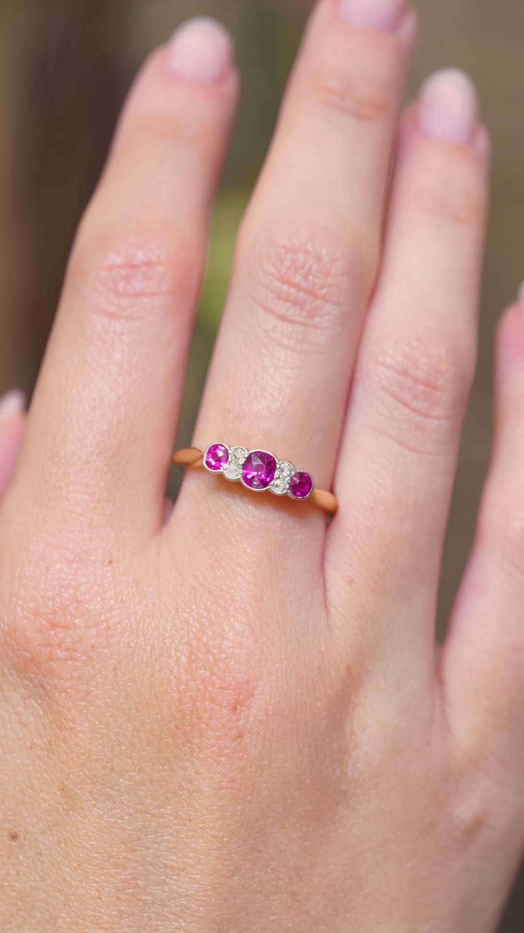 A video of an Edwardian ruby and diamond five-stone engagement ring displayed on the hand.