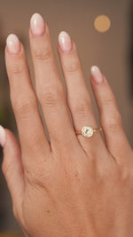 A video of a hand wearing a antique cut diamond solitaire engagement ring in yellow gold the hand slowly turns to show proportions.