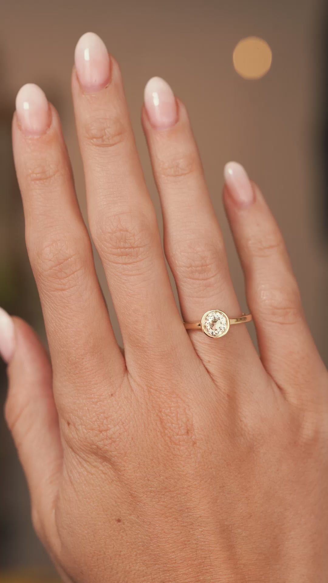 A video of a hand wearing a antique cut diamond solitaire engagement ring in yellow gold the hand slowly turns to show proportions.