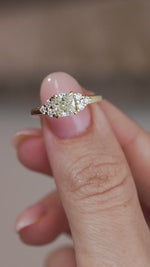 A close-up video of the yellow gold diamond ring held between fingers, showcasing its intricate trefoil design and diamond sparkle.