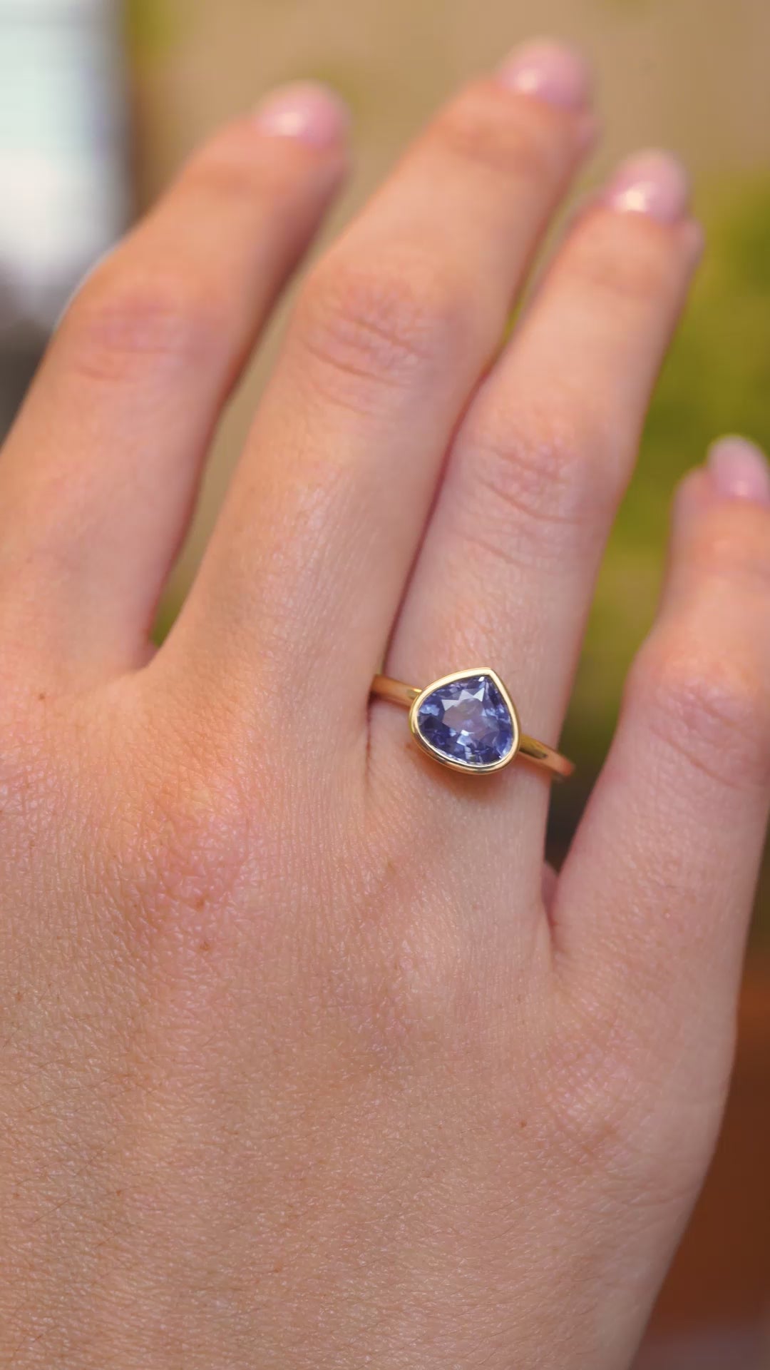 A video of a pear-cut blue sapphire solitaire ring in yellow gold displayed on the hand with an antique-inspired setting.