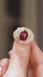 Video close-up of the 1970s ruby and diamond ring balanced on a fingertip, highlighting its dramatic domed design.
