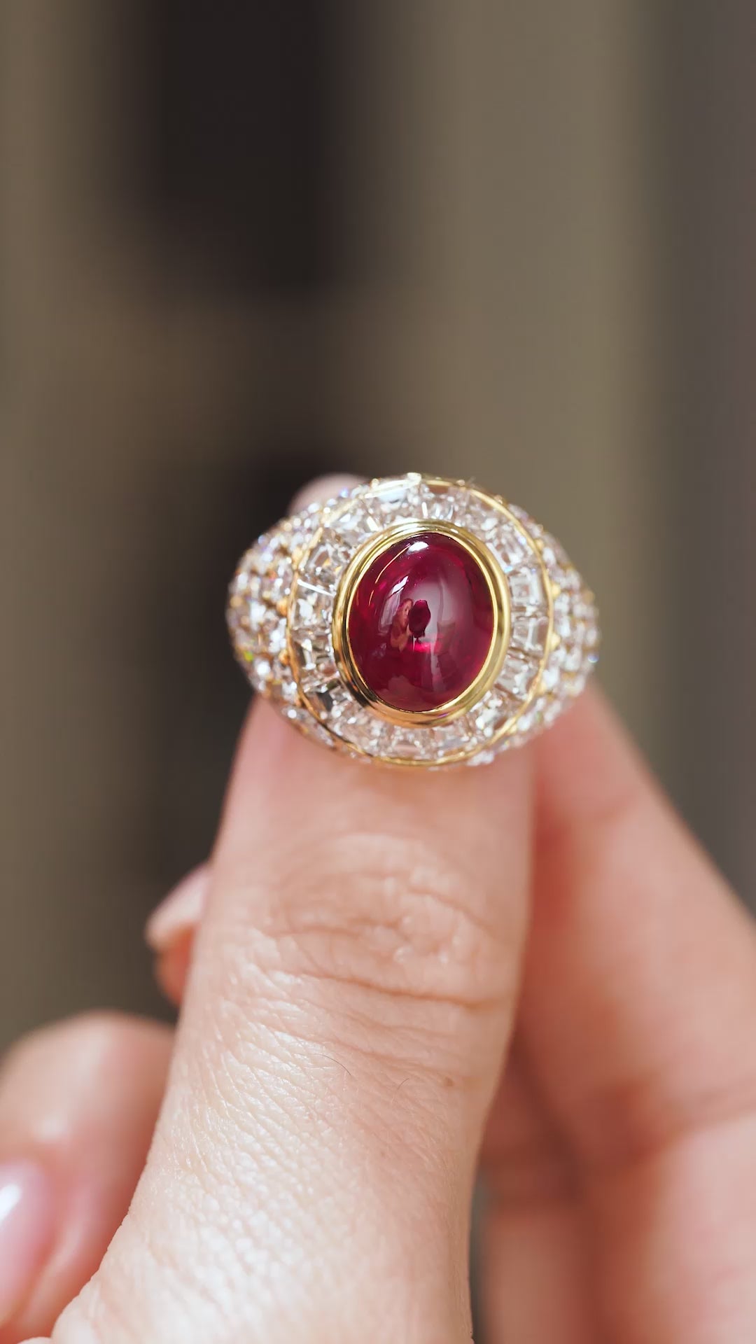 Video close-up of the 1970s ruby and diamond ring balanced on a fingertip, highlighting its dramatic domed design.