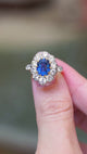 Vintage 1960s French sapphire and diamond cluster ring shown in movement between fingers.