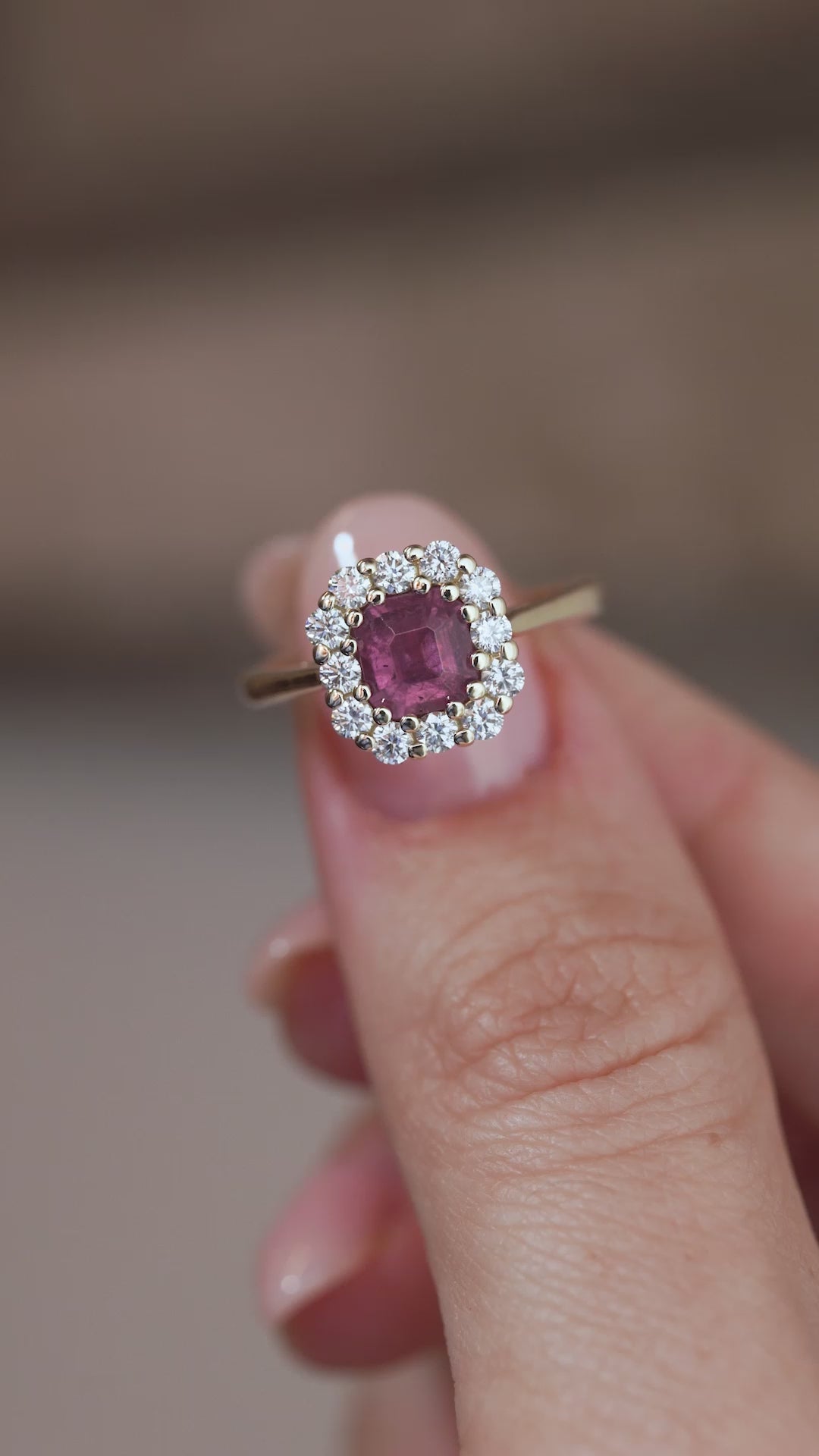 A close-up video of the sapphire engagement ring held between fingers, showcasing the gemstone's colour and intricate diamond setting.