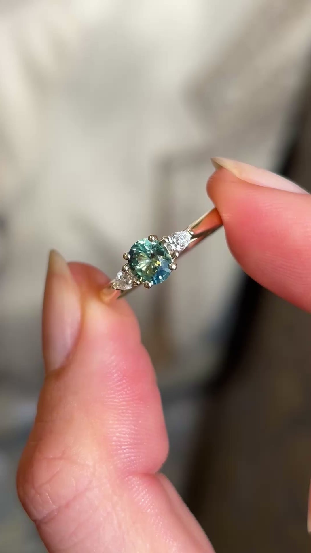 Oval green sapphire and diamond three-stone wed-fit engagement ring in yellow gold.